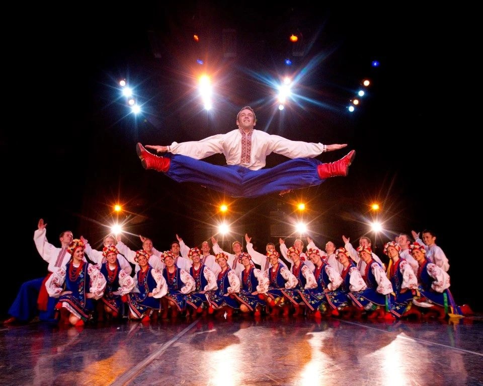 BYU Folk Dance Ensemble performers in vibrant traditional costumes on stage